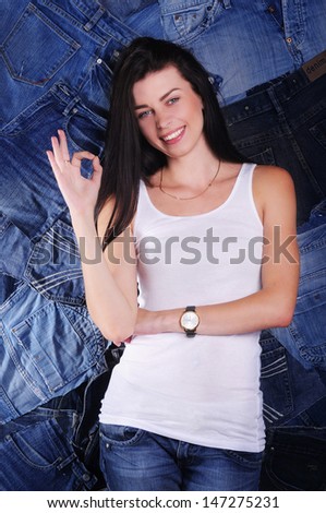happy girl on a white background in a denim shirt shows ok