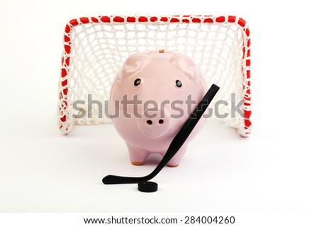 Pink piggy bank with black hockey stick and black hockey puck and red hockey gate with white net on white background