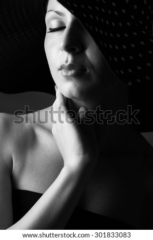 Fashion portrait of elegant woman in black and white hat and black dress - horizotal