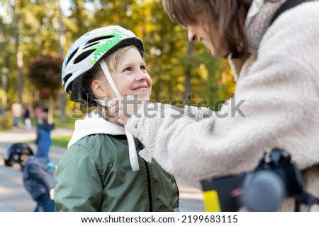 Similar – Image, Stock Photo Mother putting bicycle helmet on her son