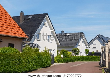 Similar – Foto Bild Häuserzeile mit verschiedenen Farben und einem blauen Himmel ,davor eine Glaswand.