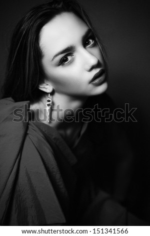 Black and White photo of pretty woman with beauty make-up and jewelry looking at camera