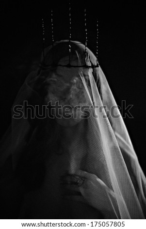 Close up of young woman with white veil, crown and smoke. Black and White Photo