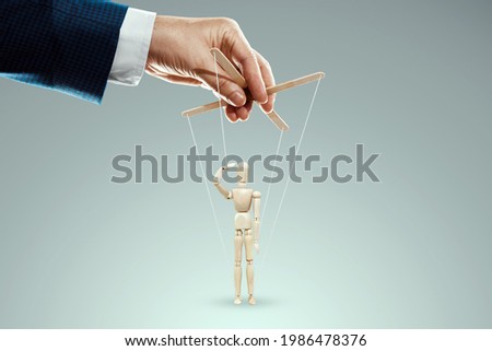 Male hand, puppeteer controls puppet, doll salutes, soldier. The concept of the army, orders, manipulation, control army Foto stock © 
