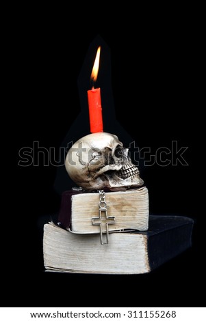 burning red candle on skull in halloween night on black background