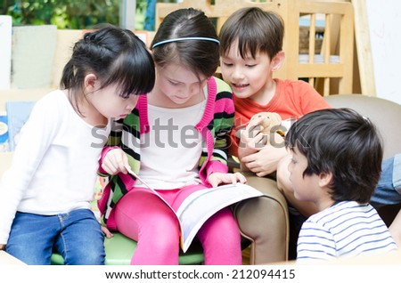 Portrait of friendly group reading book in classroom