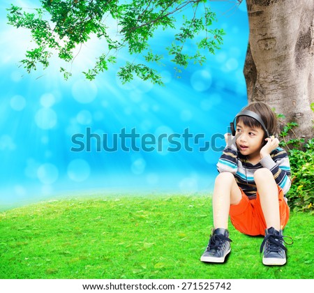 Little boy using headset in the park summer time fresh air