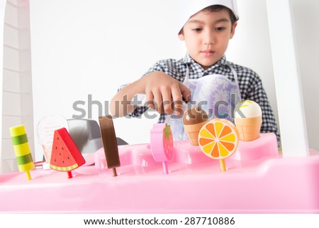 Little boy playing pretend as a sale in ice-cream shop