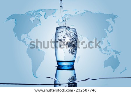 Water flowing and splashing into a glass with water world map