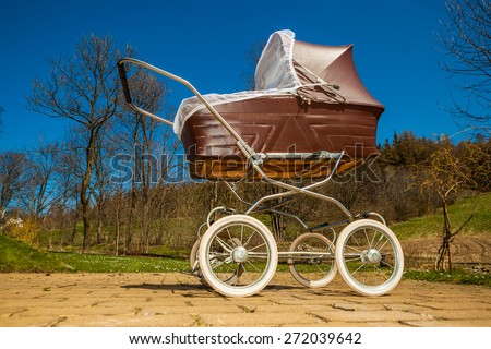 Retro style stroller baby carriage outdoors in nature on sunny day