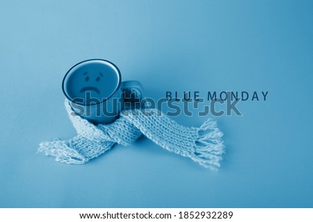 Blue cup with scarfcoffee on blue background. Blue monday concept