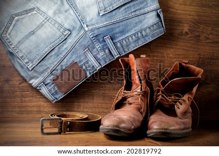 A pair of old boots, jeans and leather belt