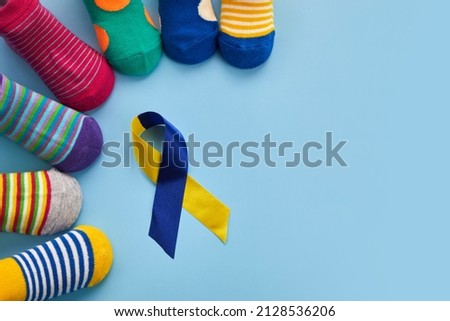 World Down syndrome day background. Down syndrome awareness concept. Socks and ribbon on blue background Stockfoto © 