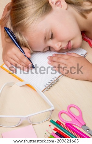 little girl fell asleep on the desk from fatigue lessons