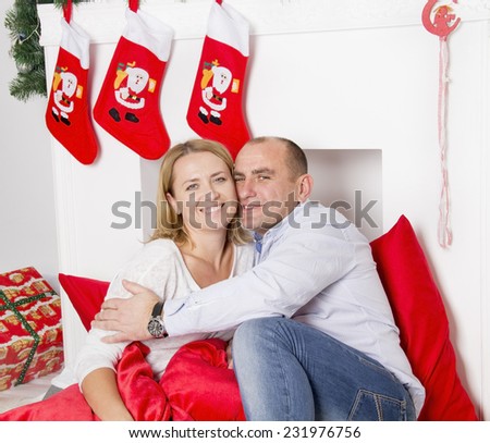the girl with the guy sitting next to the fireplace Christmas and smile