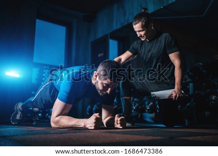 young man has workout with personal trainer in modern gym Stok fotoğraf © 