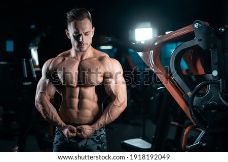 young athletic sportsman bodybuilder with muscle perfect body posing in gym Stock foto © 