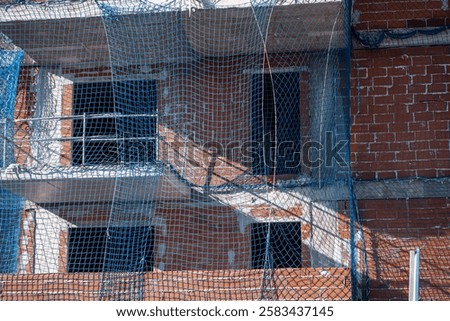 Similar – Image, Stock Photo Scaffolding with protective net and tarpaulin from frog perspective / house renovation