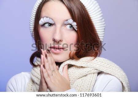 Beautiful winter young woman portrait with white eye-lashes eyelash hat violet