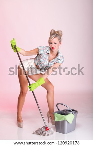 Cheerful pin up girl retro style portrait pinup Woman housewife cleaner mop pink background full lenght