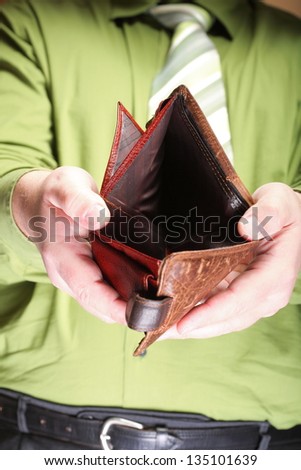Poor economy represented by empty wallet in businessman\'s hands