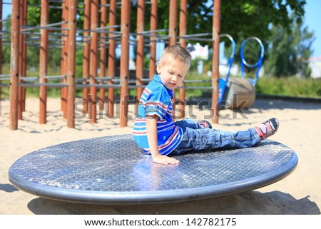 young child boy or kid playing in playground on leisure equipment