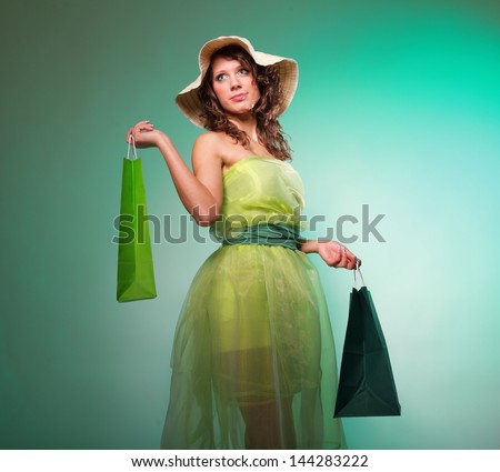 young spring woman with green shopping bags on green background