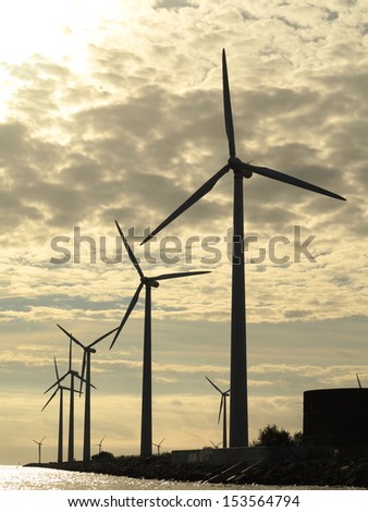 wind turbines power generator farm for renewable energy production along coast baltic sea near Denmark at sunset /sunrise. Alternative green energy. ecology.