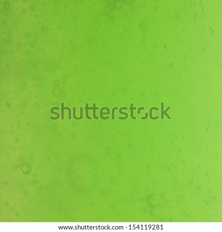 Green abstract blurred liquid background with soap bubbles. Square format