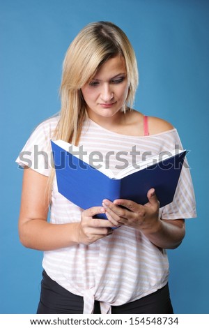 Student girl with open book, young woman reading on blue background