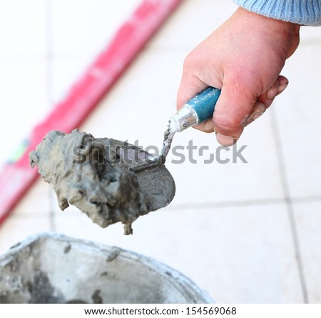 Man Construction worker is tiling at home tile floor adhesive renovation at home