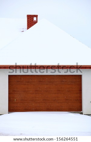 car garage door surrounded by snow, winter time
