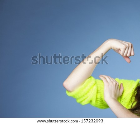 woman shows her muscles blue background strength and power concept