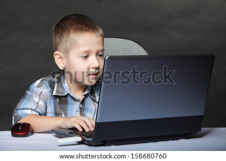 Computer addiction child boy with laptop notebook black background