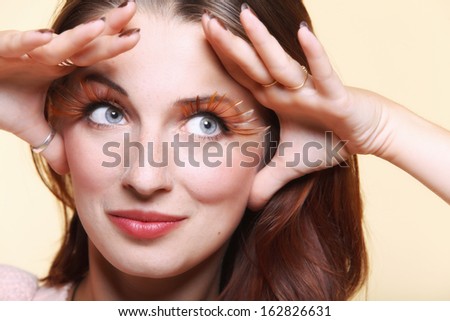 Autumn woman fashion female stylish creative make up false long brown eye lashes autumnal colour. Girl framing her face with hands
