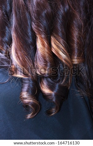 Part of brunette woman. Female hair curls. In hairdressing beauty studio.