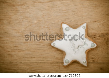 Christmas. Homemade gingerbread cake star with icing and silver decoration on wooden board. Holiday handmade concept.