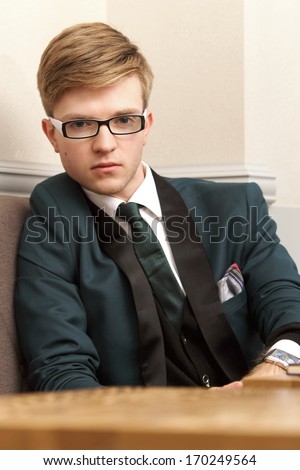 Portrait young handsome stylish man fashion model inside in cafe