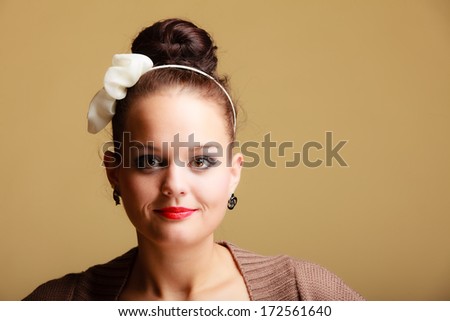 Portrait of young beautiful woman sexy girl retro style make-up and hair bun on brown background