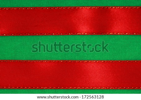 Empty banner on textile background. Red ribbon on green fabric cloth texture with copy space.