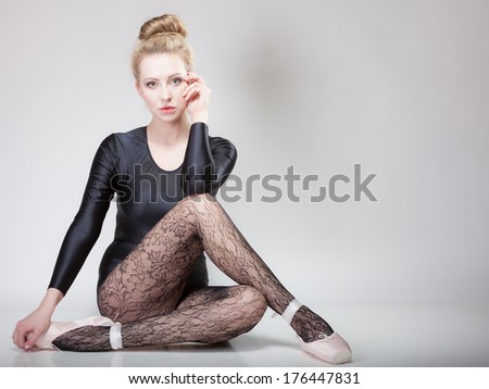 modern style beautiful woman ballet dancer sitting on floor full length studio picture gray background