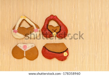 Funny colorful bikini shape gingerbread cakes cookies sweet dessert with icing and decoration on beige bamboo mat