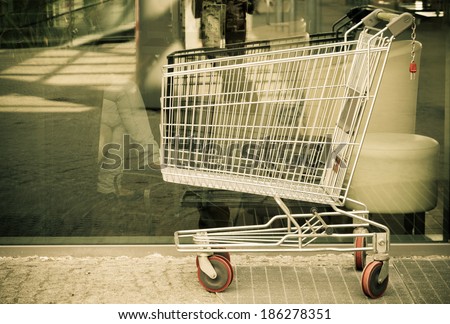 Empty shopping cart trolley. Market grocery shop and retail concept. Outdoor. Sepia one.