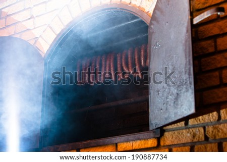 Traditional food. Smoked sausages meat hanging in domestic smokehouse.