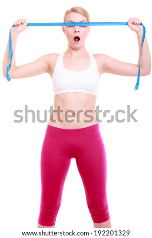 Body care diet and weight loss concept. Fitness surprised girl sporty shocked woman covering her eyes with measuring tape isolated on white