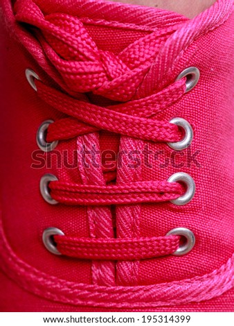 Closeup of casual vibrant pink sneakers plimsolls shoes boots on female feet. Sport fashion.
