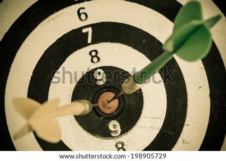 Closeup of old dirty black and white target with two darts as sport background. Skeet trap shooting.