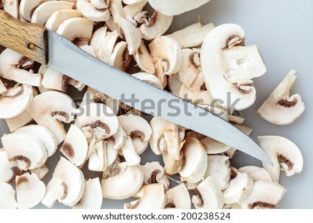 Vegetarian food. Slices of fresh white mushrooms champigonons and kitchen knife.