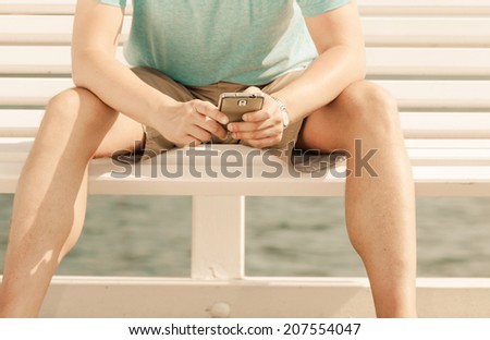 Communication technology and holidays tourism concept. Man reads message texting on mobile cell phone