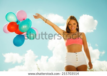 Summer holidays, celebration and lifestyle concept - beautiful woman teen girl with colorful balloons outside on beach blue sky background